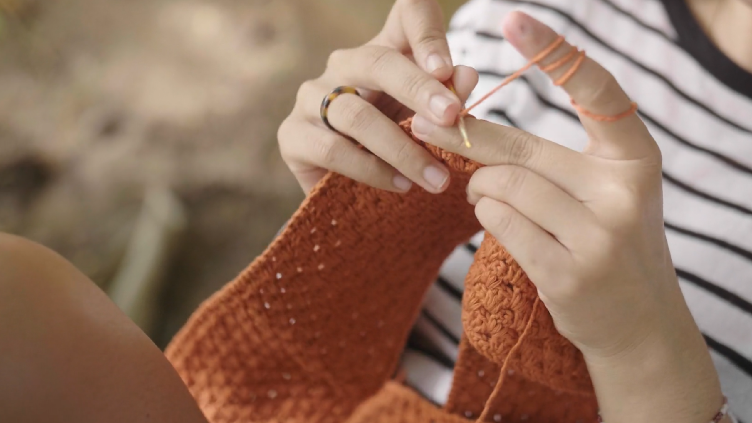 Woman crocheting an orange garment